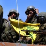 Soldados israelenses mostram uma bandeira do Hezbollah quando voltam da ação contra os guerrilheiros do Hezbollah no sul do Líbano, 25 de julho de 2006, na fronteira israelo-libanesa, perto da comunidade de Avivim.